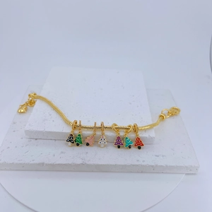 Detail of a gold snake chain bracelet featuring seven colorful enamel mushroom charms