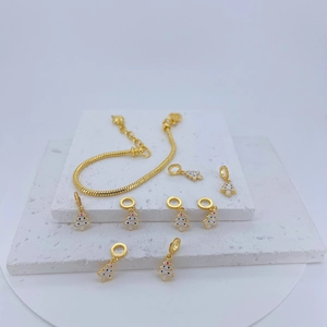 Detailed view of DIY Christmas tree enamel charms on a gold snake chain bracelet