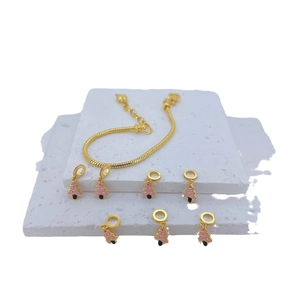 Golden snake chain bracelet with pink enamel Christmas tree charms on stone pedestals