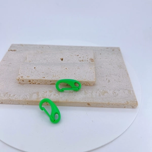 Pair of bright green copper macaron lobster clasps on beige stone for DIY keychains