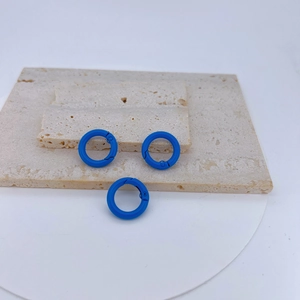 Detailed view of three bright blue spring ring clasps on a textured stone surface