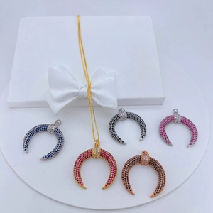 Detalle de colgantes de media luna con circonitas de colores y cadena de oro fino