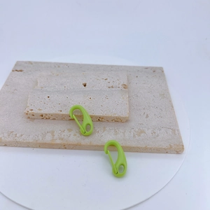 Macro detail of green macaron lobster clasps on stone base for DIY jewelry making and crafts