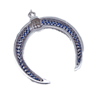 Elegante colgante de cuerno plateado con circonitas azules sobre fondo blanco