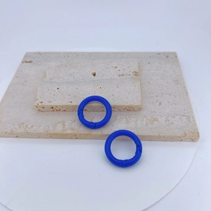 Close-up of royal blue round spring o-rings on stone slabs for DIY jewelry making