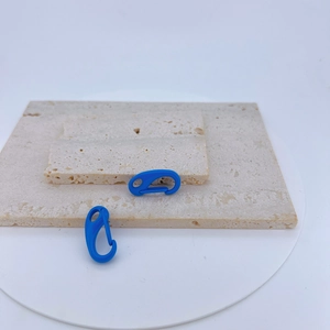 Macro detail of blue macaron spring carabiner hooks on stone display stand