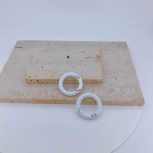 Macro view of two white round spring gate rings on stone for DIY jewelry and keychain