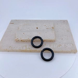 Close-up of two black matte spring O-rings on a textured stone display for DIY jewelry