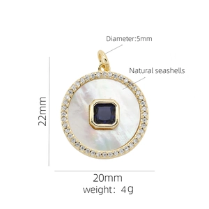 Macro detail of 18K gold heart pendant with shell inlay and blue gemstone