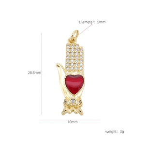 Macro detail of 18k gold plated palm heart pendant with red enamel and white zirconias