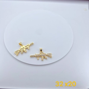 Detailed view of gold plated machine gun pendants with cubic zirconia and 32mm size scale