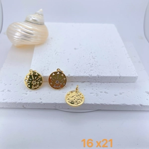 Detalle del colgante dorado grabado Luck con medidas 16x21mm sobre piedra mineral blanca