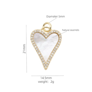 Macro detail of a gold heart pendant with white mother of pearl and cubic zirconia stones