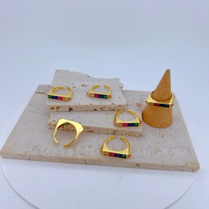 Detail van goudkleurige verstelbare ringen met kleurrijke rechthoekige zirkonia