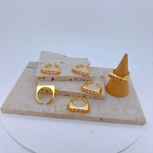Macro detail van verstelbare gouden ringen met rechthoekige roze zirkonia steenzettingen