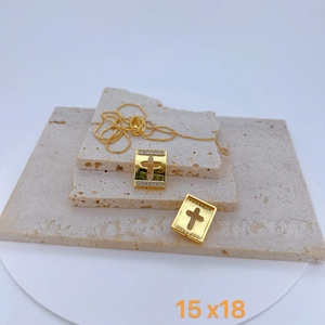 Gold hollow cross necklace set with cubic zirconia pendant on travertine stone display
