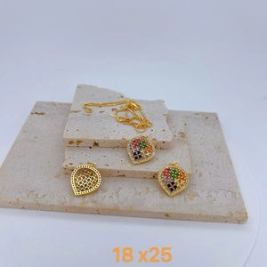 Elegant gold hollow pendant with rainbow crystals on natural beige travertine stone