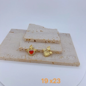 Detail view showing front and back of heart wing pendant with red enamel and crystals