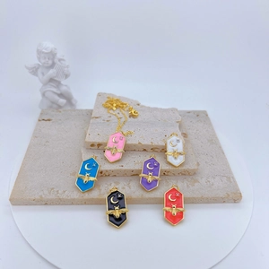 Detailed macro view of colorful enamel hexagon charms with gold bee and moon motifs