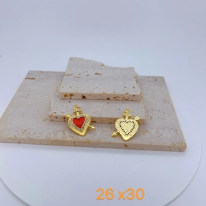 Detail of heart with wings pendants in gold finish with red enamel and zircon stones