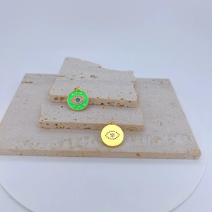 Detailansicht von Evil Eye Anhängern in Gold und grünem Email mit Zirkon-Besatz