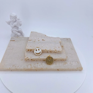 Pendentifs smiley élégants plaqués or avec émail blanc sur socle en pierre de travertin