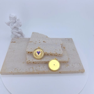 Detail of gold evil eye pendants with purple heart enamel and colorful zircon stones