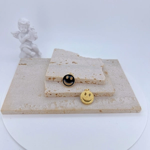 Gros plan de pendentifs smiley en or et émail noir pour la fabrication de bijoux DIY