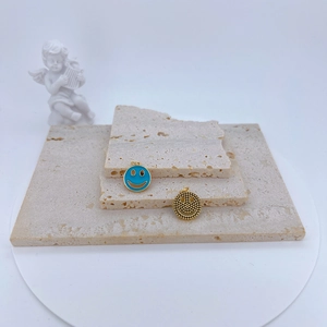 Détails des pendentifs visage souriant creux en or et émail bleu sur support pierre