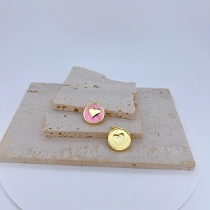 Detalle de colgantes de corazón en oro de 18k con esmalte rosa y circón para joyería DIY
