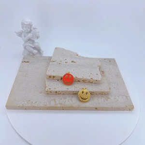 Gros plan de pendentifs évidés plaqués or avec émail rouge et texture de points fins