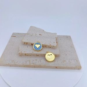Vista detallada de colgantes de corazón bañados en oro de 18k sobre piedra elegante