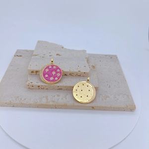 Pink enamel evil eye pendant with gold sun starburst motifs on travertine stone