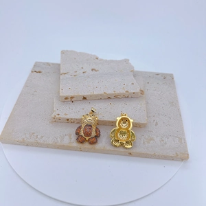 Vue détaillée des pendentifs ours dorés avec zircons pavés oranges et blancs
