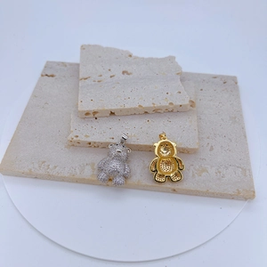 Vue macro de pendentifs ours en argent et or avec zircons et dos en nid d'abeille