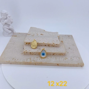 Vista detallada del dije de ojo turco con esmalte azul y acabado chapado en oro texturizado