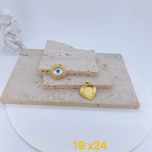 Golden heart charm with evil eye zircon inlay and honeycomb back view on stone