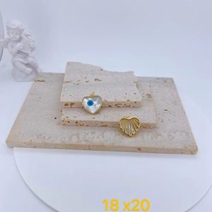 Detailed view of heart-shaped evil eye charms with mother of pearl and gold plating