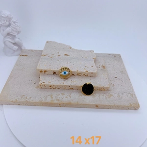 Macro shot of 14x17mm evil eye and black enamel charms on decorative stone tiles