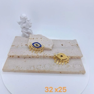 Detailed macro view showing a 32x25mm evil eye pendant with blue enamel and tassels