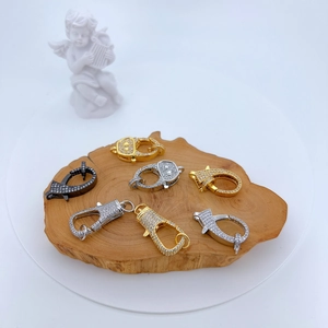 Micro-paved cubic zirconia lobster clasps in gold and silver on natural wood base