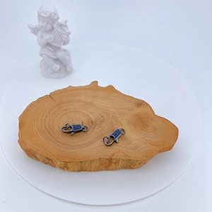 Makro-Detail von gunmetal Karabinerverschlüssen mit blauen Zirkonia auf Holzstruktur