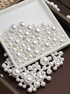 Detail van ronde witte ABS-parels met recht gat voor het maken van DIY-sieraden