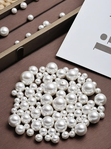 Macro-opname van witte ronde parels met gaatjes voor DIY-sieraden op een donkere ondergrond