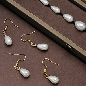 Elegant gold-plated hook earrings with teardrop ABS pearls displayed in a jewelry box