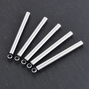 Fünf lange Edelstahl-Rohranhänger in Silber auf dunklem Steingrund für Schmuck