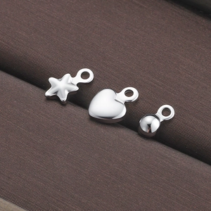 Set de dijes de corazón y estrella en acero inoxidable pulido en joyero oscuro