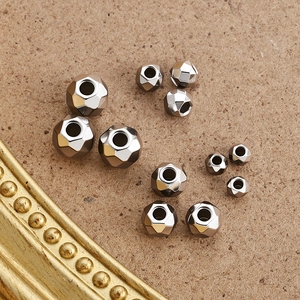 Perles facettées en acier inoxydable pour bijoux DIY en diverses tailles sur fond texturé