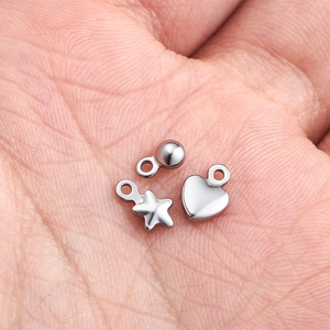 Vista macro de dijes de estrella y corazón de acero inoxidable pulido para joyería artesanal