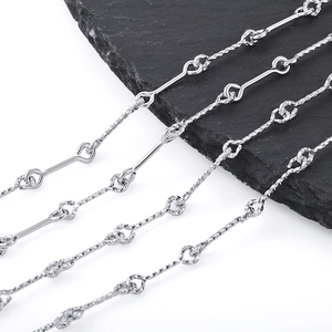 Polished stainless steel chain necklaces in various link styles on a slate display